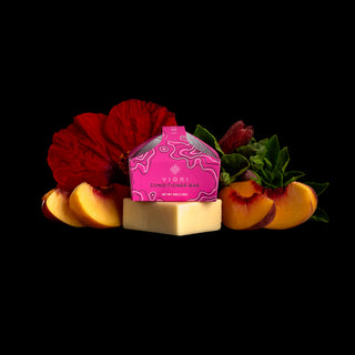 Viori Peach Hibiscus Conditioner Bar with pink packaging, sliced peach, and a hibiscus flower